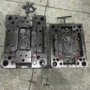 Open metal injection mold used to manufacture a decorative phone case.